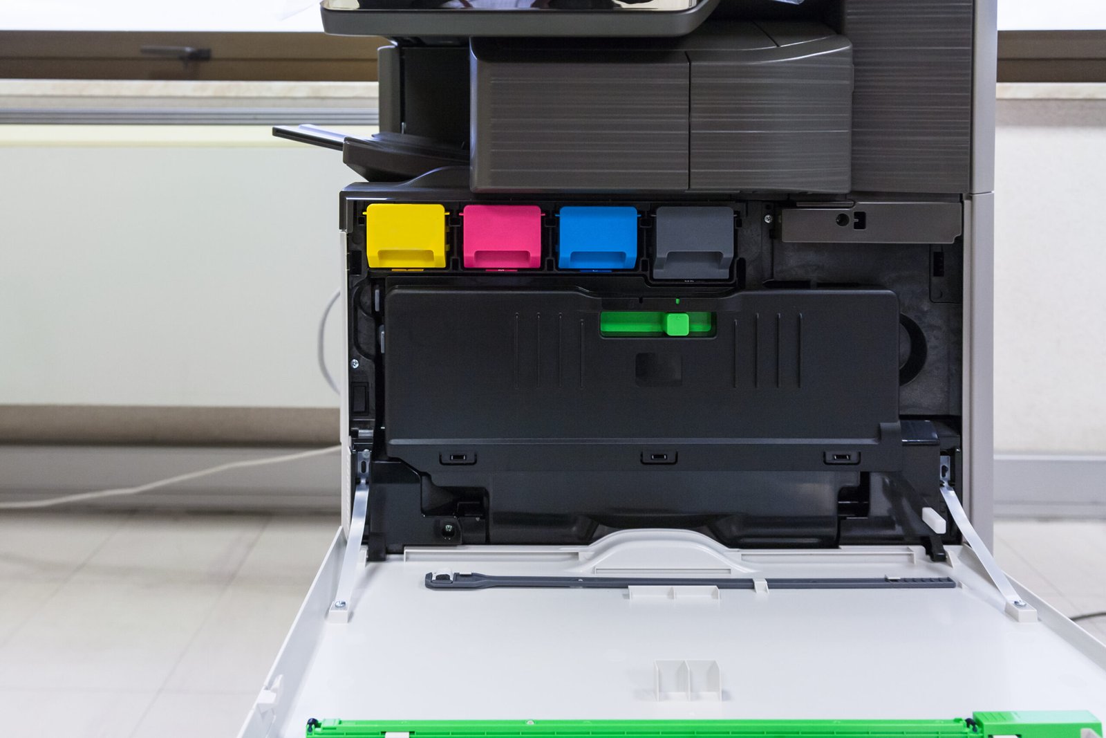 copier with four toner cartridges with open cover in office hall